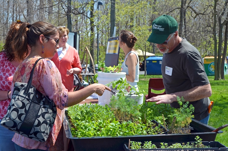 A woman pointing at plants while a Master Gardener explains at a JCC Earth Day celebration